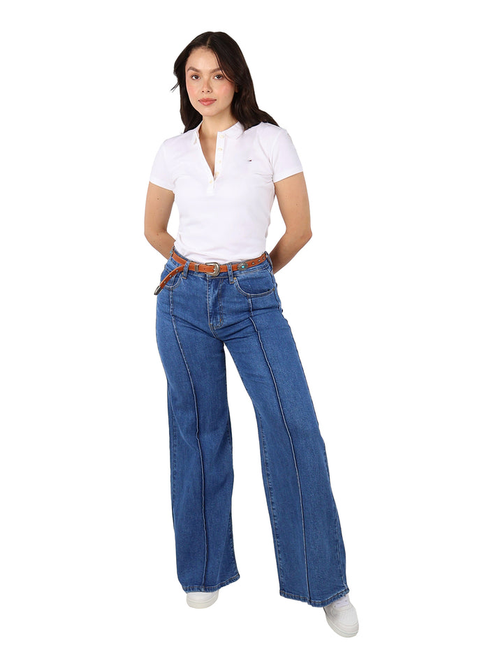 Mujer vistiendo pantalones jeans anchos de color azul con costuras verticales y cinturón marrón.