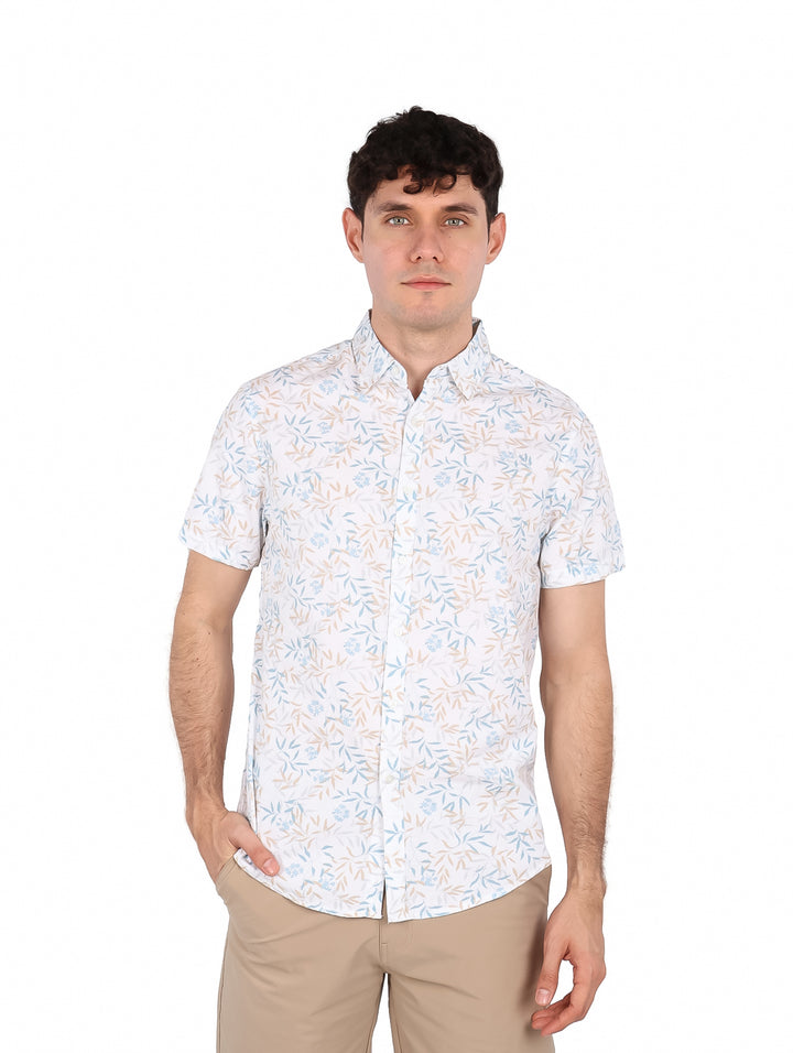 Hombre vistiendo camisa blanca de manga corta con estampado floral en tonos azul y beige.