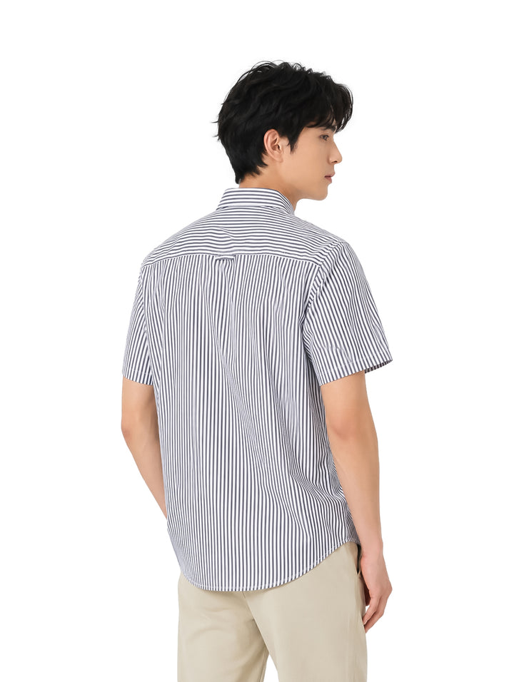 Hombre vistiendo una camisa de manga corta con rayas verticales azules y blancas.