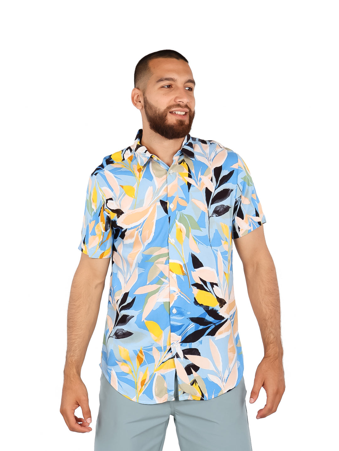 Hombre vistiendo camisa de manga corta con estampado floral multicolor en tonos azul, amarillo y blanco.