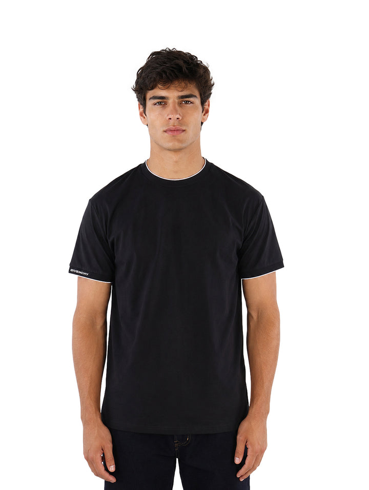 Hombre vistiendo playera Givenchy color negro con detalles blancos en cuello y mangas.