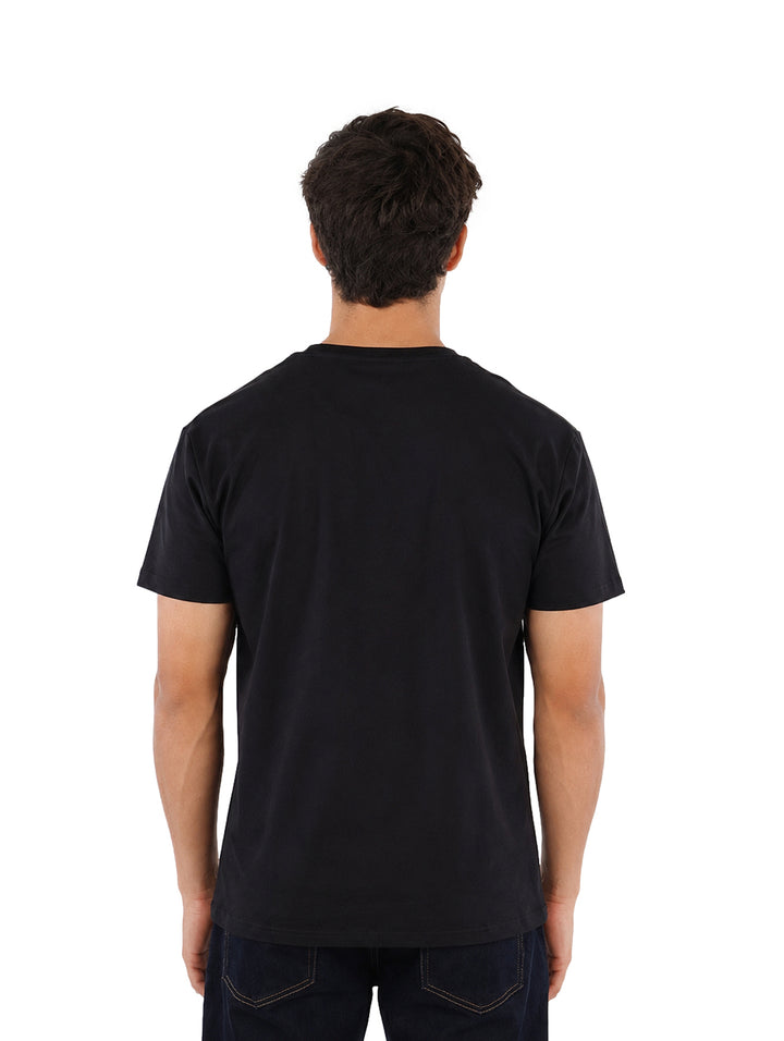 Hombre vistiendo una playera Givenchy de color negro con letras rojas en el pecho.