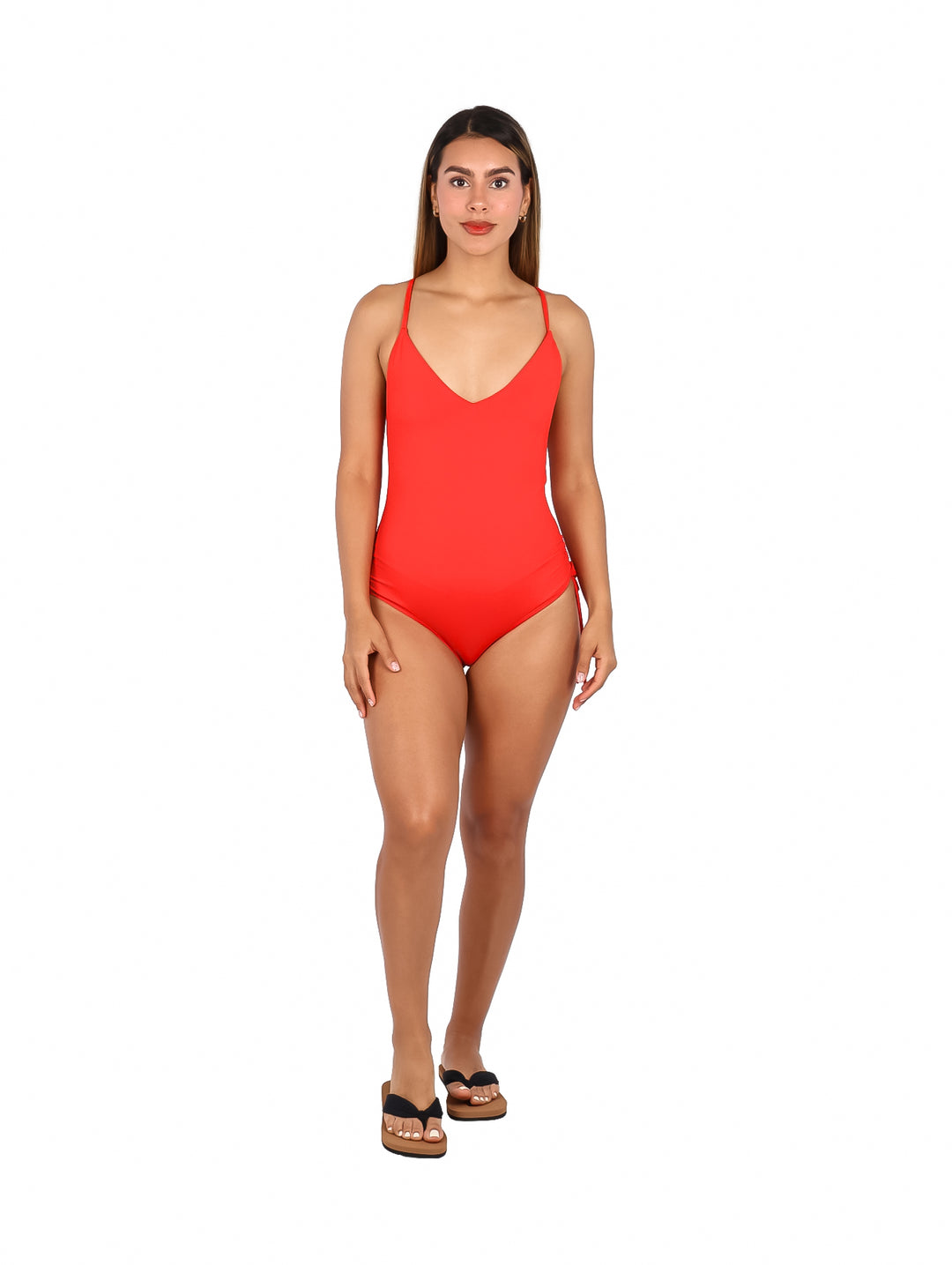 Mujer vistiendo un traje de baño enterizo color rojo fuego con cuello en V y tirantes delgados.