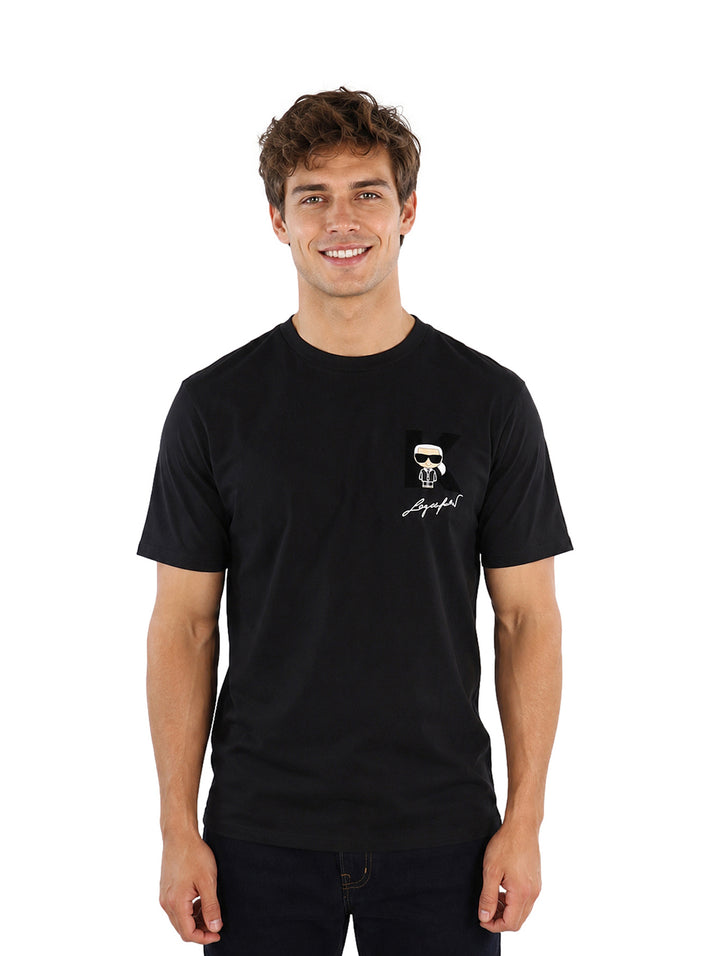 Hombre vistiendo playera negra de manga corta con detalle gráfico en el pecho de la marca Karl Lagerfeld.