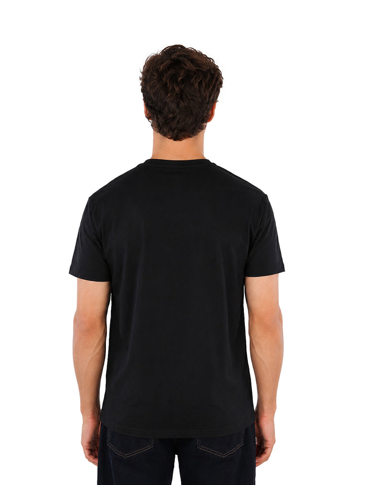 Hombre vistiendo playera negra de manga corta con detalle gráfico en el pecho de la marca Karl Lagerfeld.