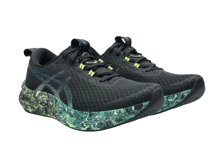 Tenis deportivos ASICS color negro con suela jaspeada en tonos verde y amarillo.