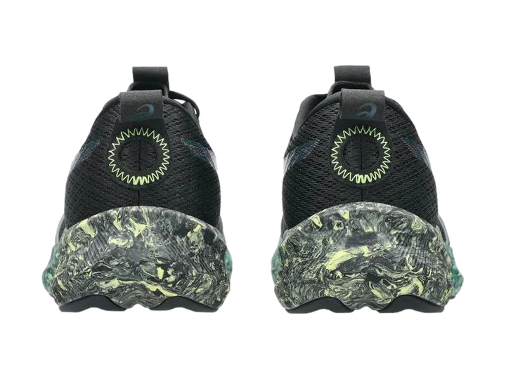 Tenis deportivos ASICS color negro con suela jaspeada en tonos verde y amarillo.