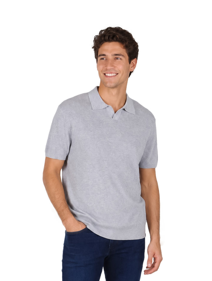 Hombre vistiendo una playera polo color gris de manga corta y cuello.