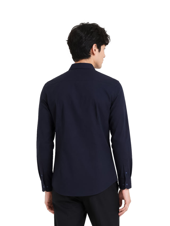 Hombre vistiendo una camisa de color marino de manga larga con cuello y botones.