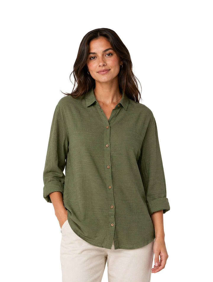 Mujer usando una camisa verde oliva de botones y cuello, estilo casual.