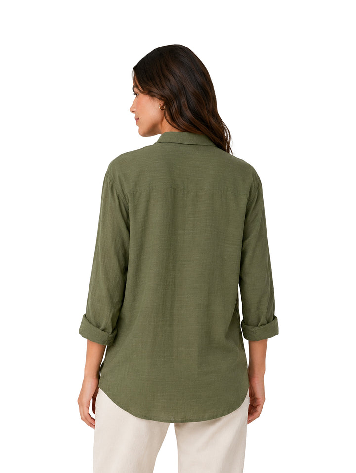 Mujer usando una camisa verde oliva de botones y cuello, estilo casual.