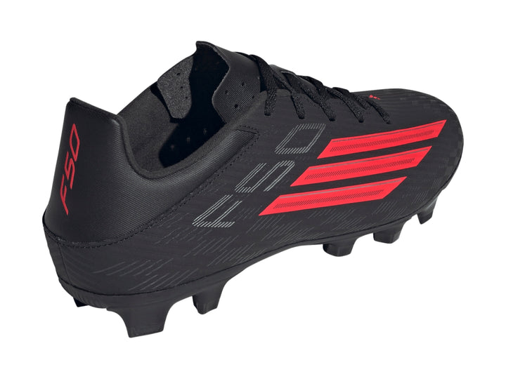 Botas de fútbol Adidas F50 color negro con franjas rojas laterales y suela de tacos.