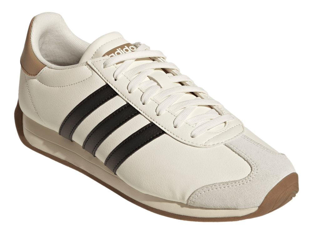 Tenis Adidas color blanco crema con tres franjas negras laterales y suela color café.