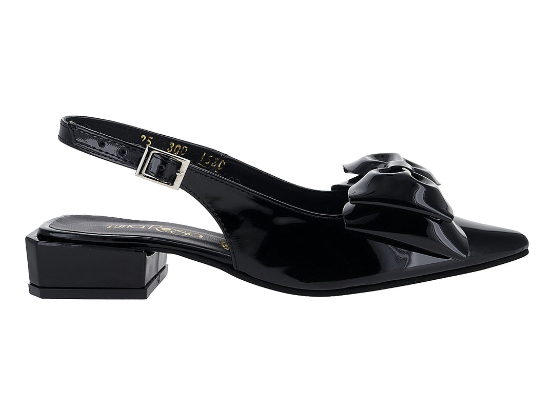 Zapato negro de charol con tacón bajo, moño decorativo al frente y correa trasera con hebilla.