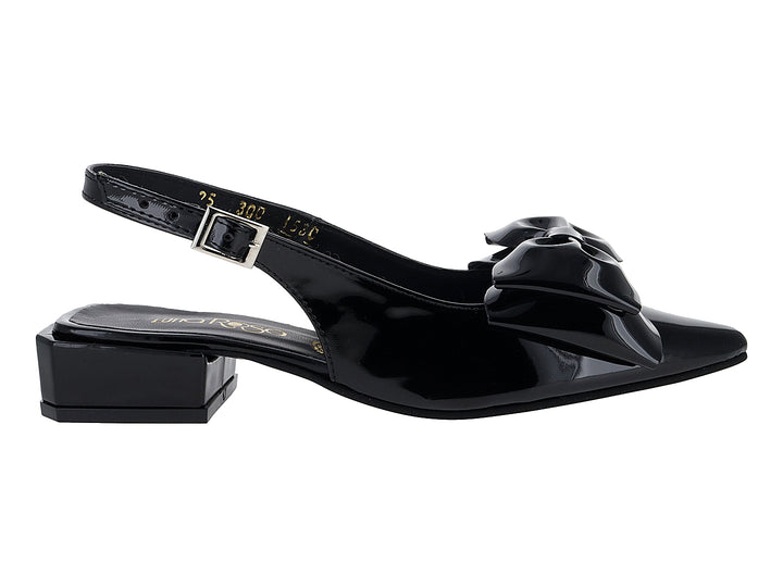 Zapato negro de charol con tacón bajo, moño decorativo al frente y correa trasera con hebilla.