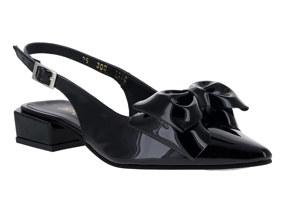 Zapato negro de charol con tacón bajo, moño decorativo al frente y correa trasera con hebilla.