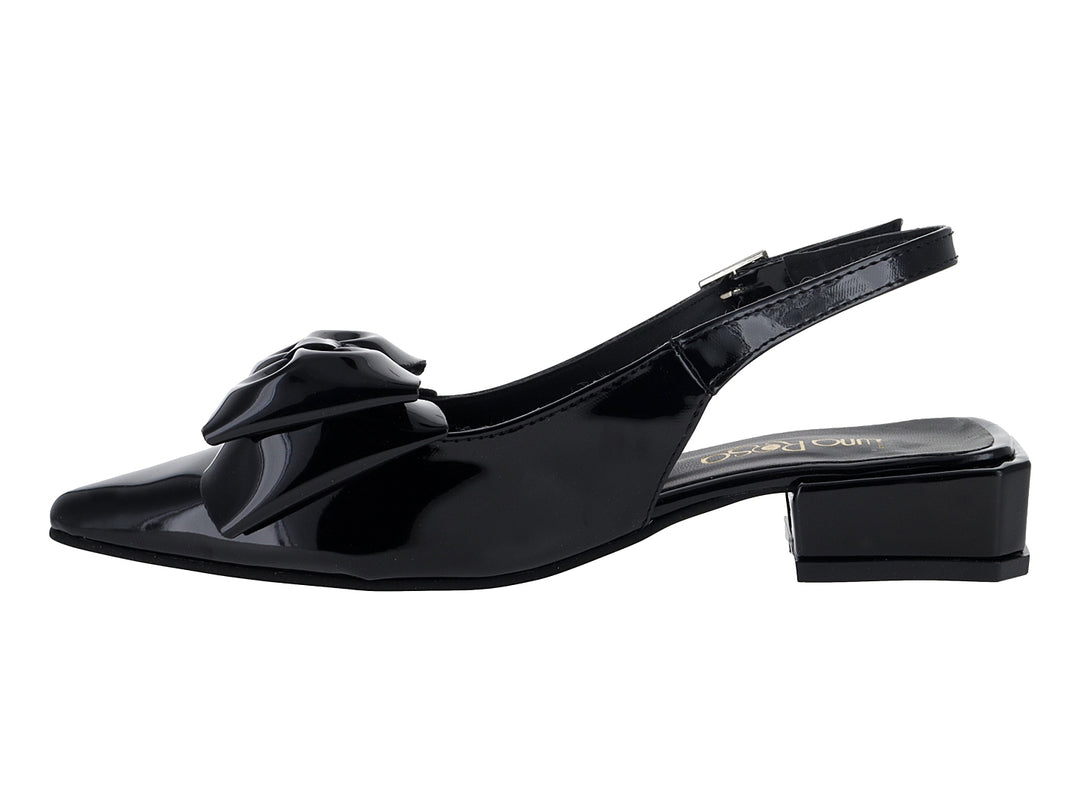 Zapato negro de charol con tacón bajo, moño decorativo al frente y correa trasera con hebilla.