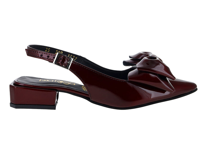 Zapato de charol color merlot con moño decorativo, tacón cuadrado bajo y correa con hebilla.