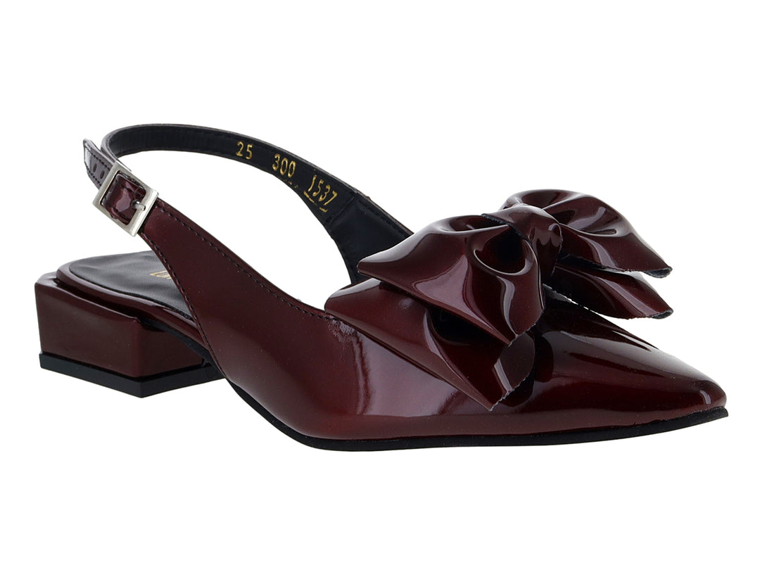 Zapato de charol color merlot con moño decorativo, tacón cuadrado bajo y correa con hebilla.