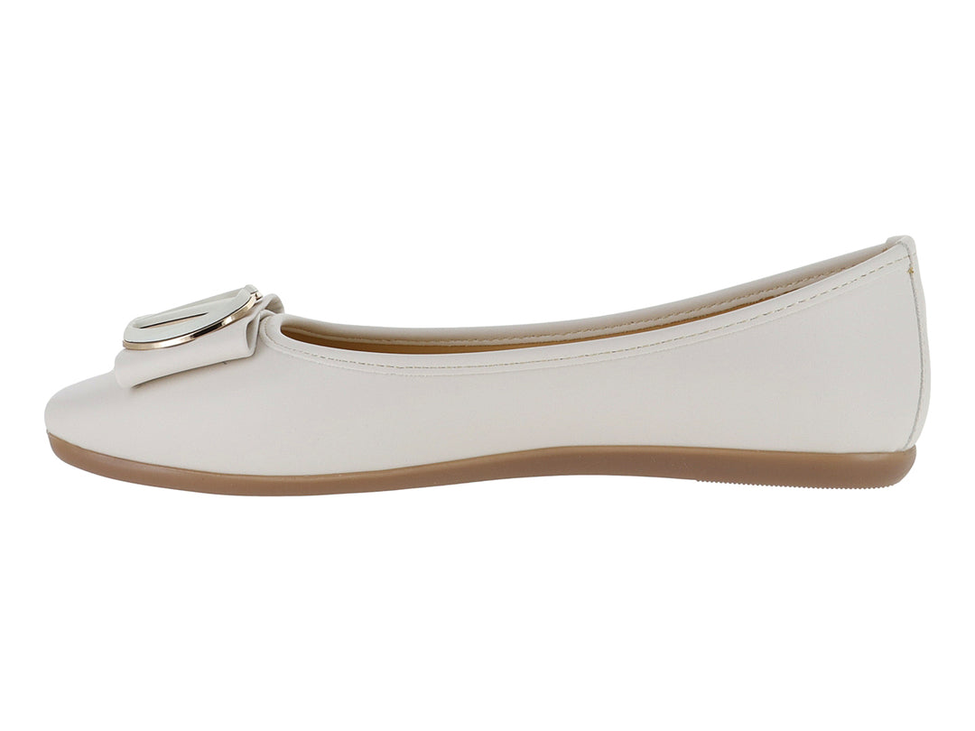 Zapato plano color latte con punta redonda y detalle de hebilla metálica en la parte superior.