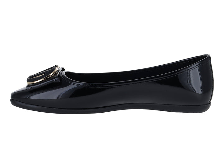 Zapato plano de charol negro con detalle de hebilla dorada en la punta.