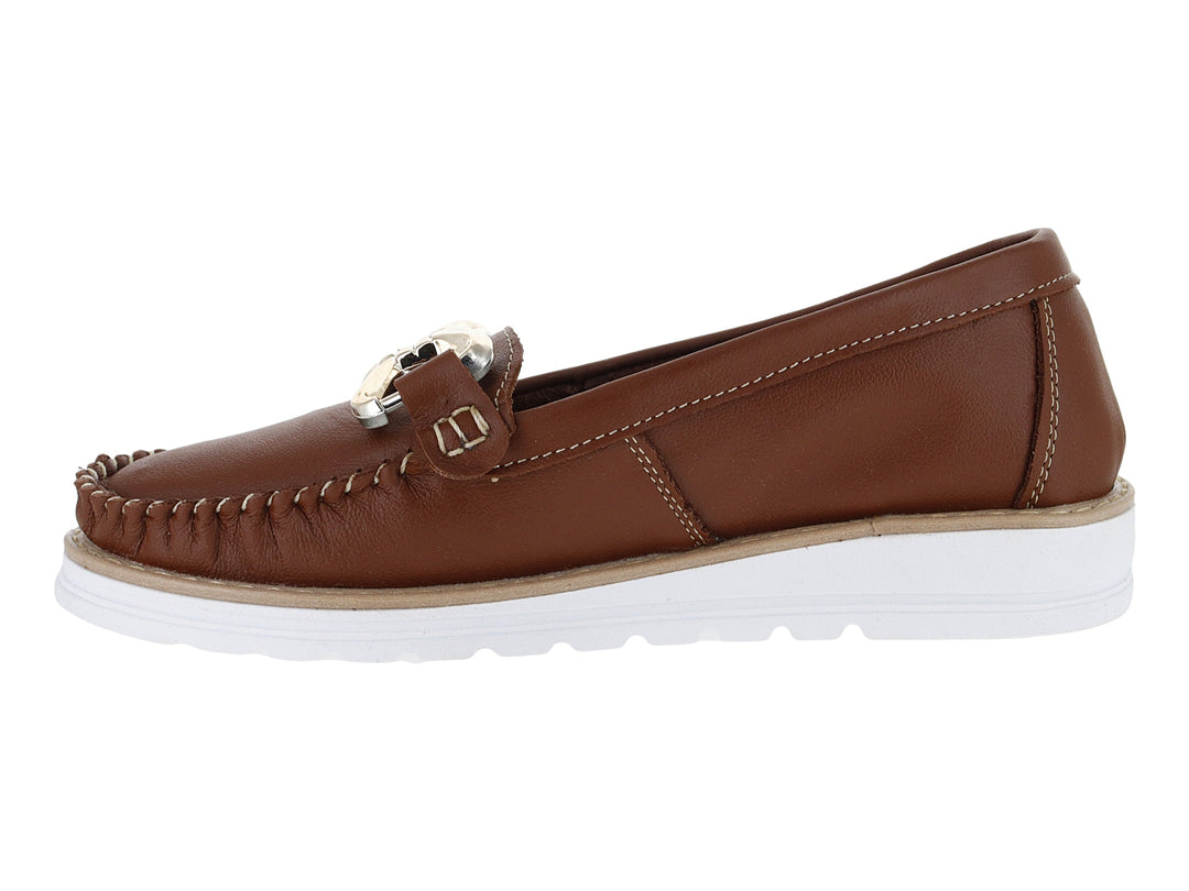 Mocasines color tan para mujer con suela blanca y detalle de hebilla dorada.