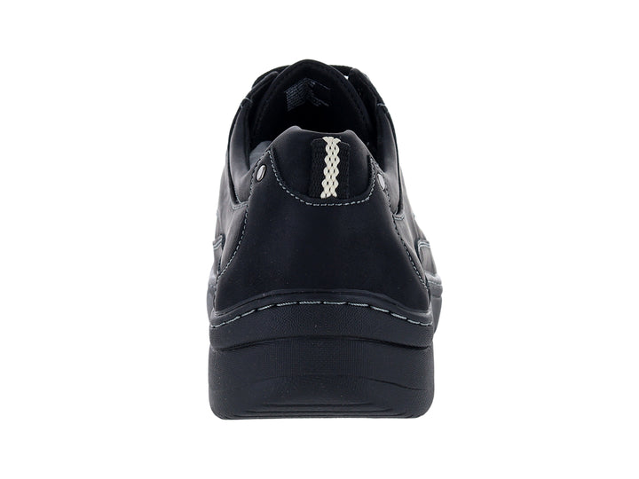 Zapato confort negro con cordones y costuras blancas contrastantes sobre fondo blanco.