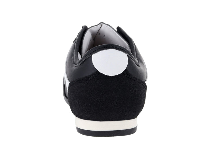Tenis deportivos Andrax color negro con franjas blancas laterales y suela blanca.