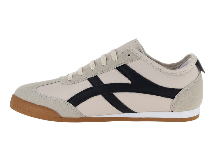 Tenis Andrax color latte con franjas negras y suela de goma marrón.