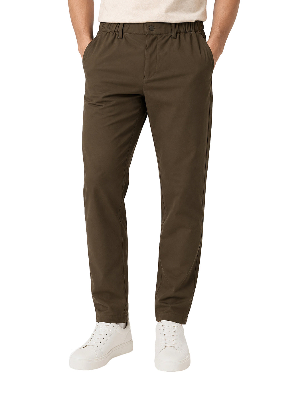 Hombre vistiendo pantalón color olivo oscuro de corte casual y tenis blancos.