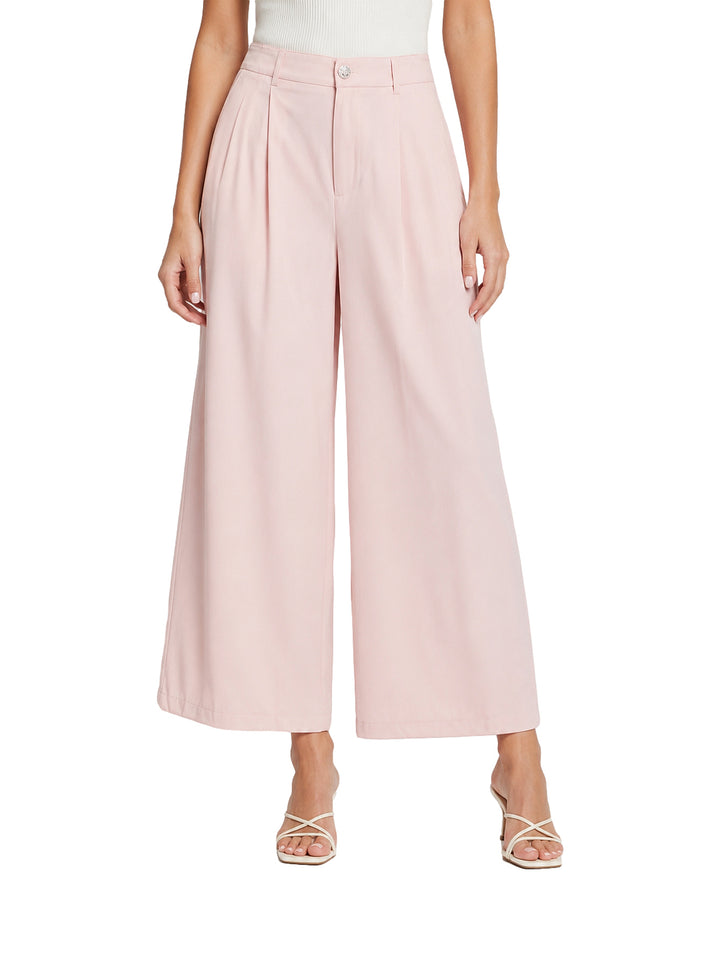 Mujer vistiendo pantalón de pierna ancha color rosa baby pink con pinzas frontales.