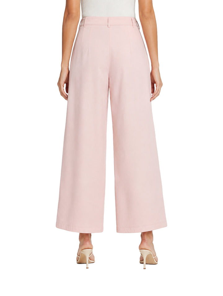 Mujer vistiendo pantalón de pierna ancha color rosa baby pink con pinzas frontales.