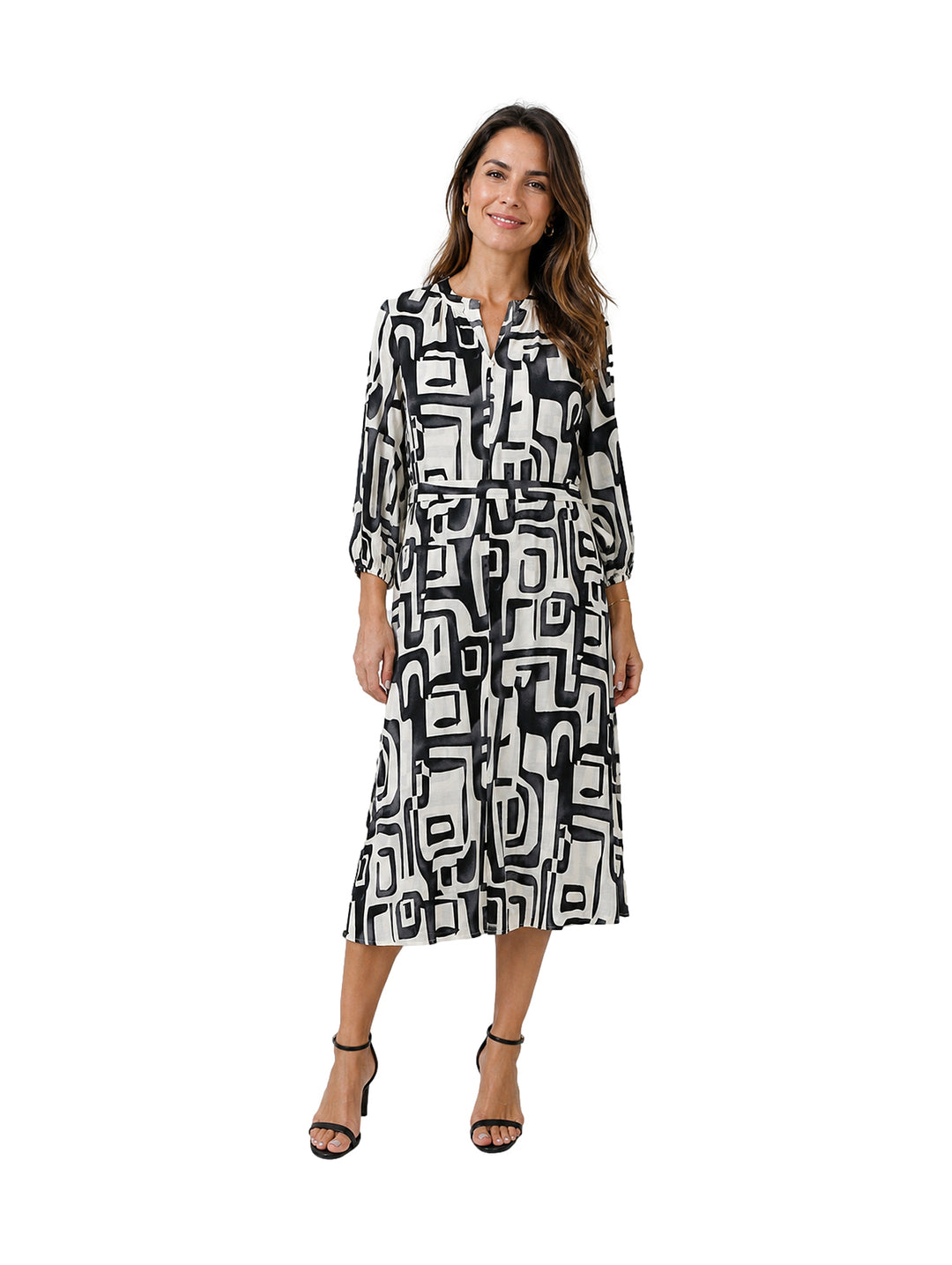Mujer vistiendo un vestido midi de manga larga con estampado geométrico en blanco y negro.