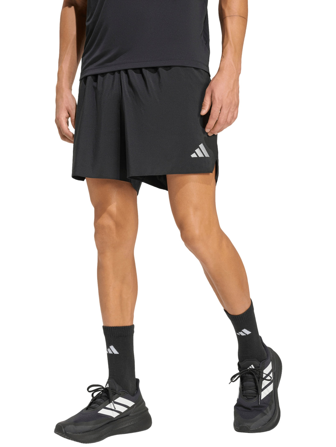 Hombre vistiendo shorts deportivos negros de marca Adidas para running.