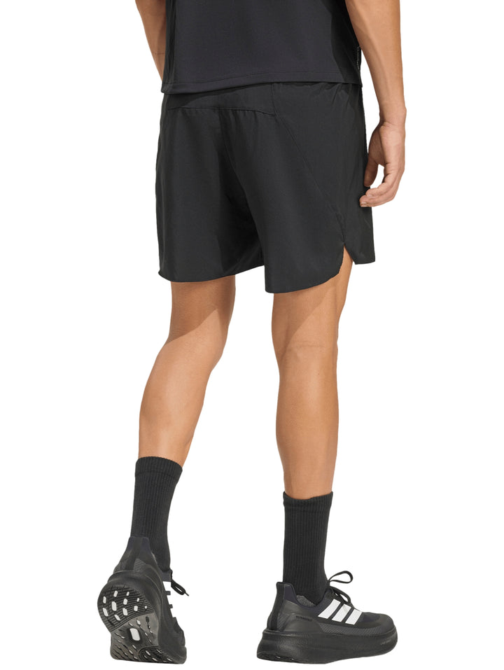 Hombre vistiendo shorts deportivos negros de marca Adidas para running.