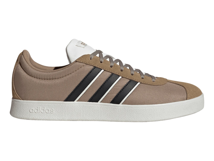 Tenis Adidas color marrón con tres franjas negras laterales y suela blanca.