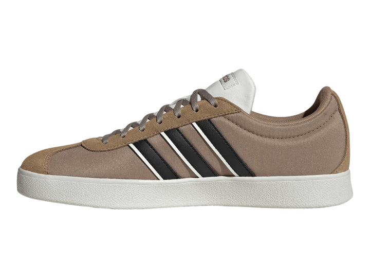Tenis Adidas color marrón con tres franjas negras laterales y suela blanca.