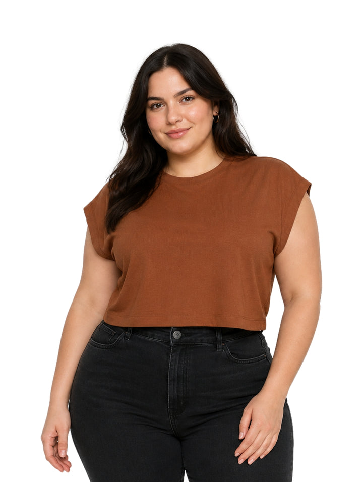 Mujer vistiendo una blusa corta de color café con cuello redondo y manga corta.