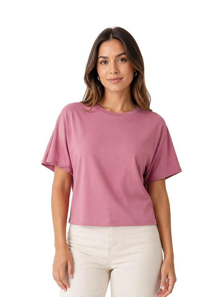 Mujer vistiendo una blusa de color rosa oscuro con cuello redondo y manga corta.