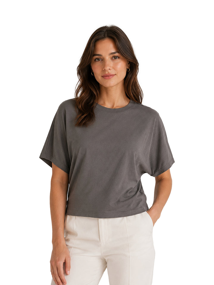 Mujer modelando una blusa color gris oscuro de manga corta y cuello redondo.