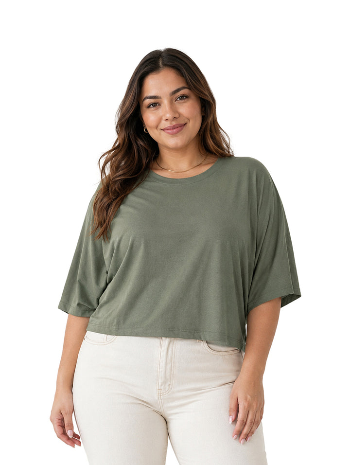 Mujer vistiendo una blusa color verde de corte holgado y cuello redondo.