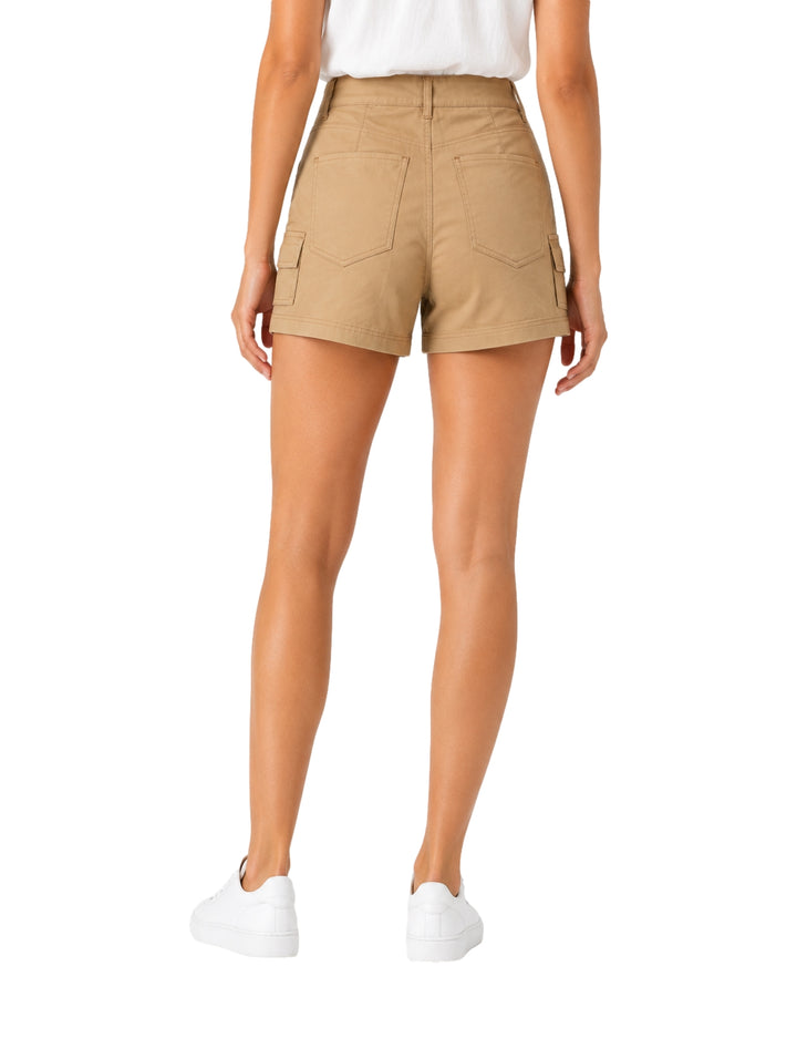 Mujer vistiendo shorts color kaki con bolsillos laterales y calzado blanco.