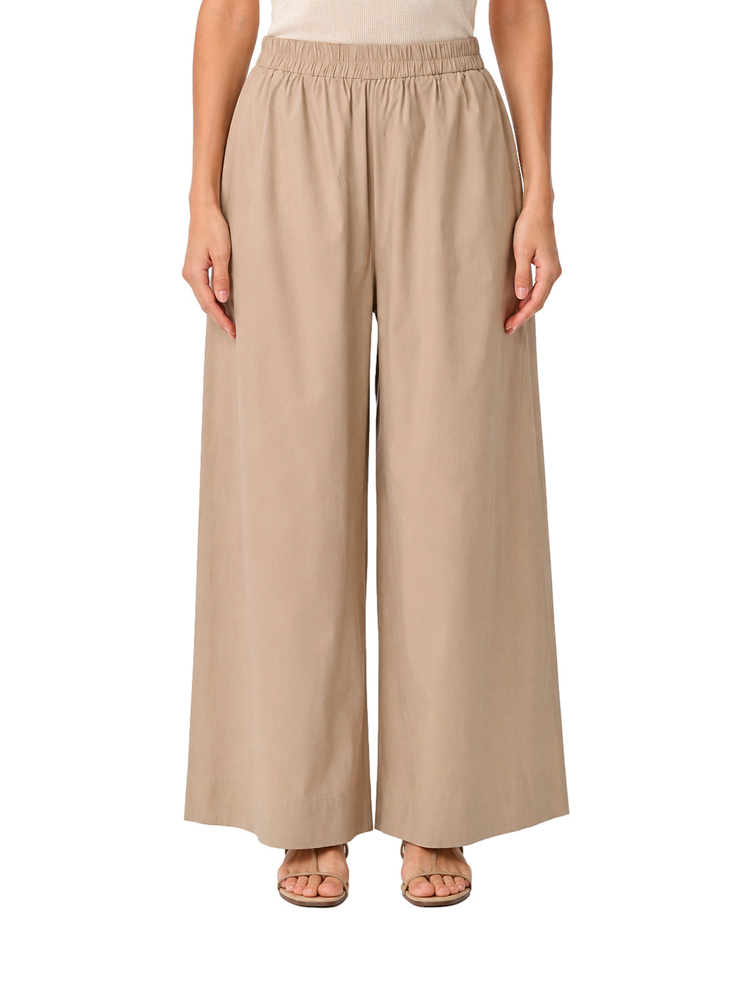 Mujer vistiendo pantalones de pierna ancha en color camel con cintura elástica.