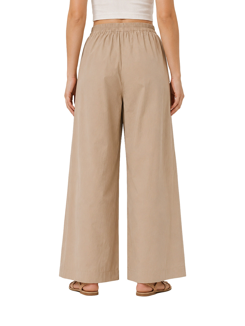 Mujer vistiendo pantalones de pierna ancha en color camel con cintura elástica.