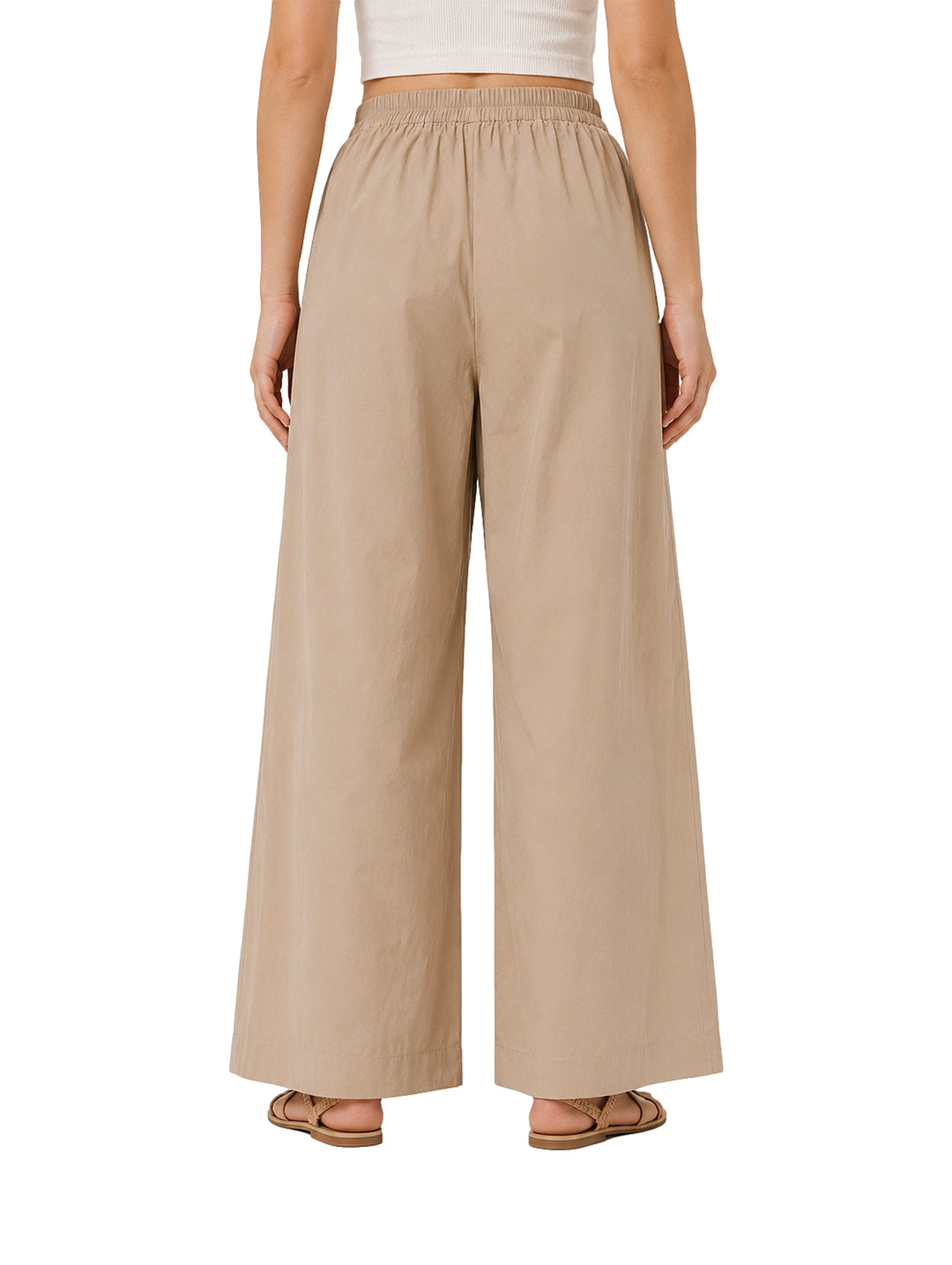 Mujer vistiendo pantalones de pierna ancha en color camel con cintura elástica.