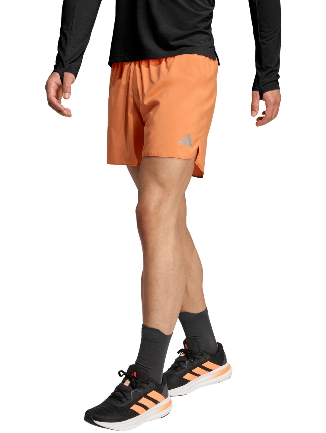 Hombre vistiendo shorts deportivos color naranja de la marca Adidas