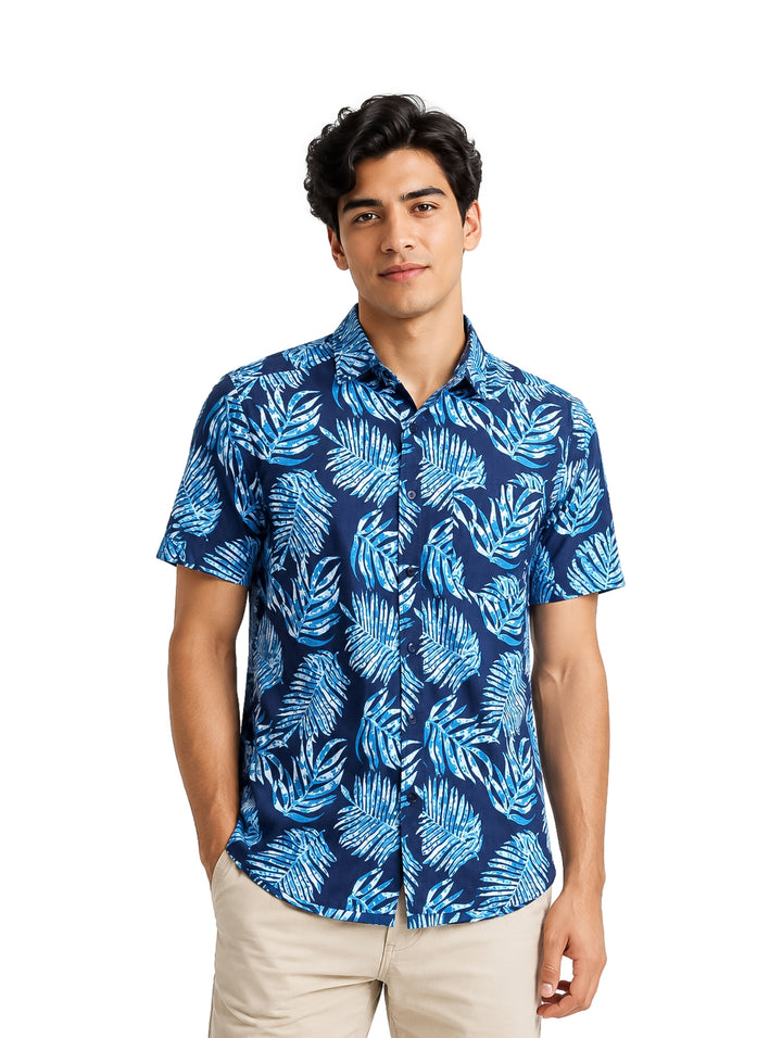 Hombre vistiendo camisa casual de manga corta color azul marino con estampado de hojas en tonos claros.