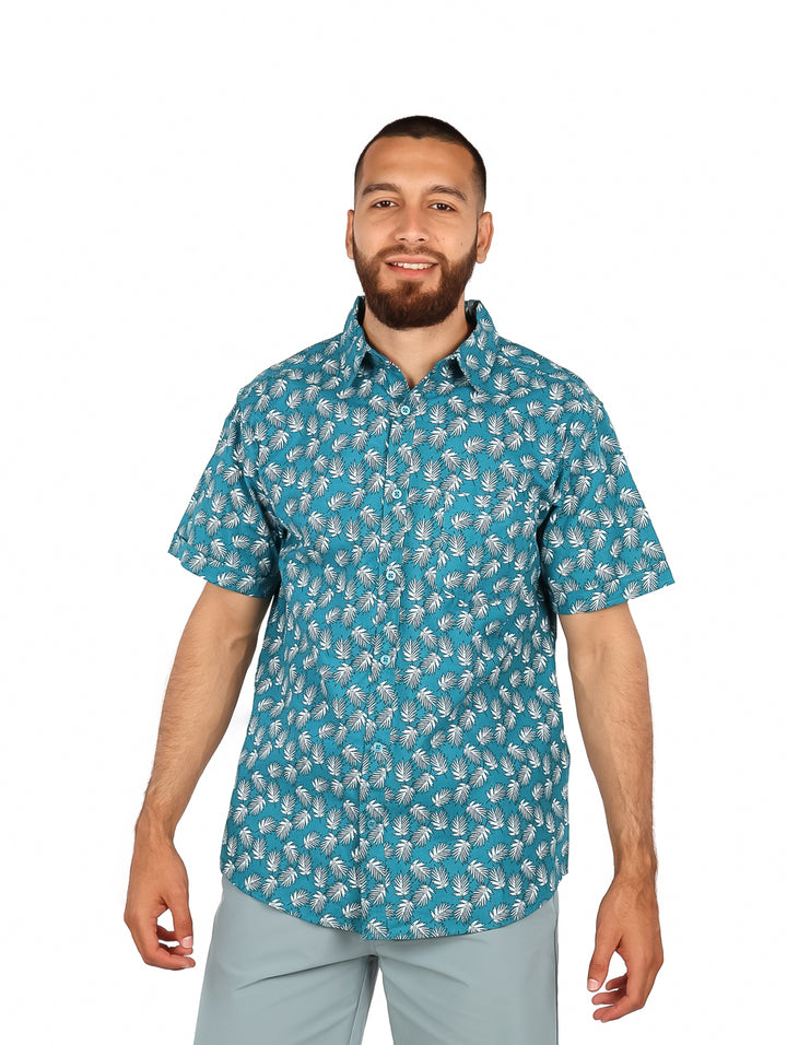 Hombre vistiendo una camisa casual de manga corta color azul claro con estampado de hojas blancas.
