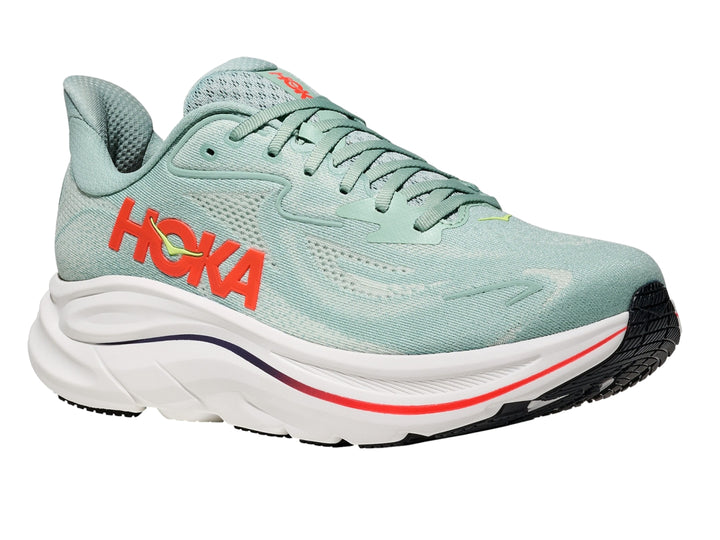 Tenis deportivos HOKA Clifton 10 color verde salvia con suela blanca y detalles en naranja.