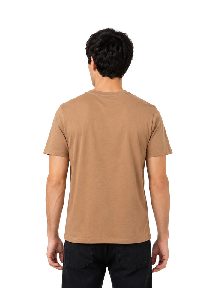Hombre usando playera color café marca Wrangler con estampado gráfico frontal.
